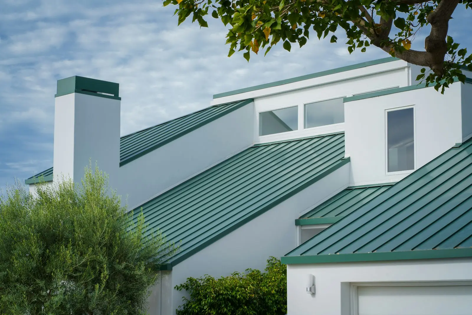 White home with new sage standing-seam metal roof