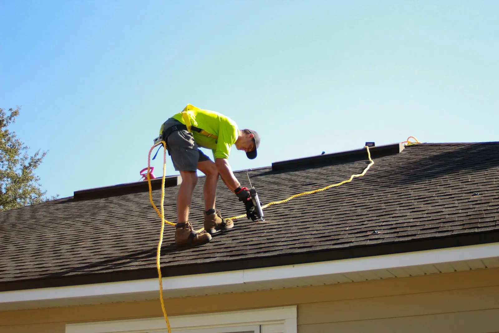 Roofer fastening panels on a steep pitch